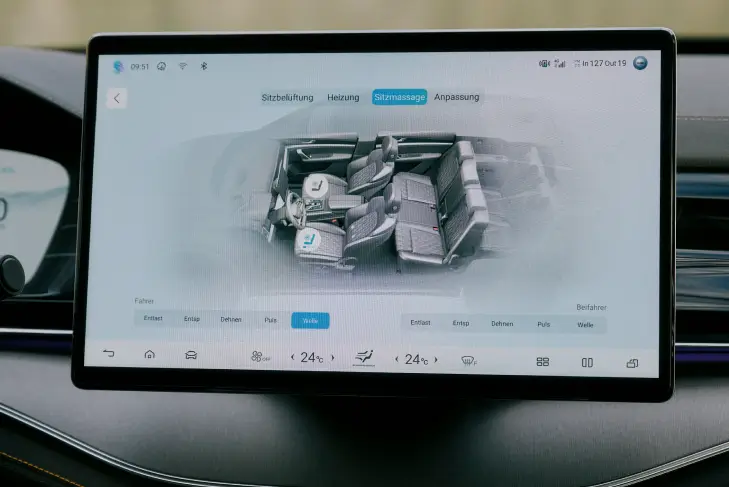 Das zentrale Touchscreen-Display im Innenraum eines BYD Tang zeigt die Bedienoberfläche für die Sitzeinstellungen. Eine 3D-Darstellung des Fahrzeuginnenraums mit hervorgehobenen Sitzen ist sichtbar.