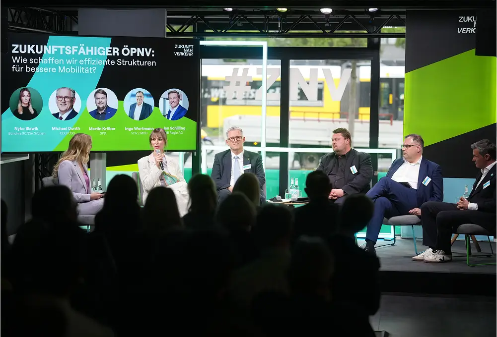 Eine Podiumsdiskussion mit mehreren Personen auf einer Bühne, begleitet von einer großen Präsentationsfolie zum Thema „Zukunftsfähiger ÖPNV“.