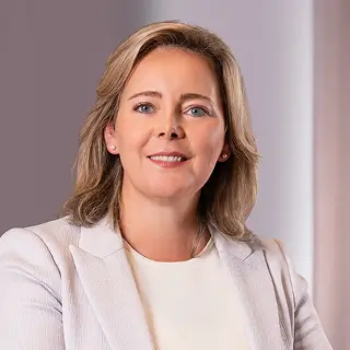 Eine Person steht vor einem Bildschirm und hält eine Präsentation zu Unternehmenszielen und Nachhaltigkeit.