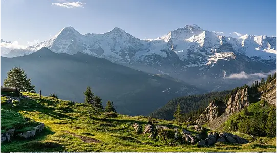 Luftaufnahme einer schneebedeckten Bergstation mit umliegenden Alpen im Winter.