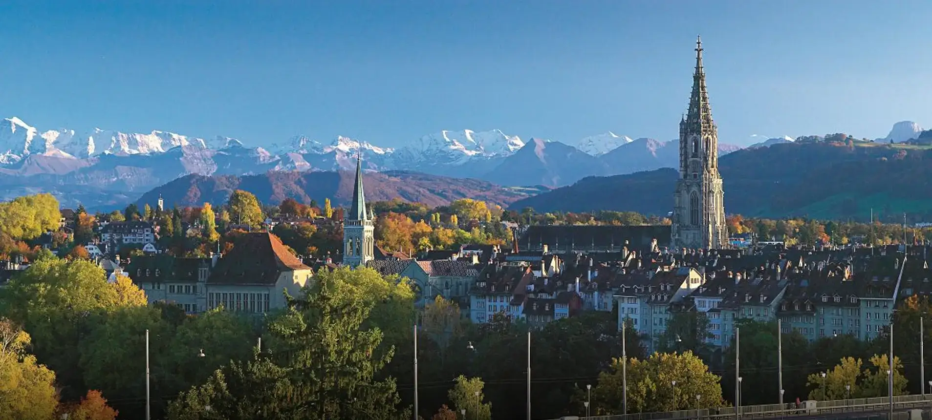Blick auf die Altstadt von Bern mit dem Berner Münster und den Alpen im Hintergrund.