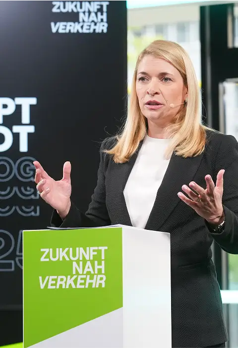 Eine Rednerin hält eine Präsentation vor einem Publikum, begleitet von einer großen Leinwand mit der Aufschrift „Hauptstadt Dialog“.