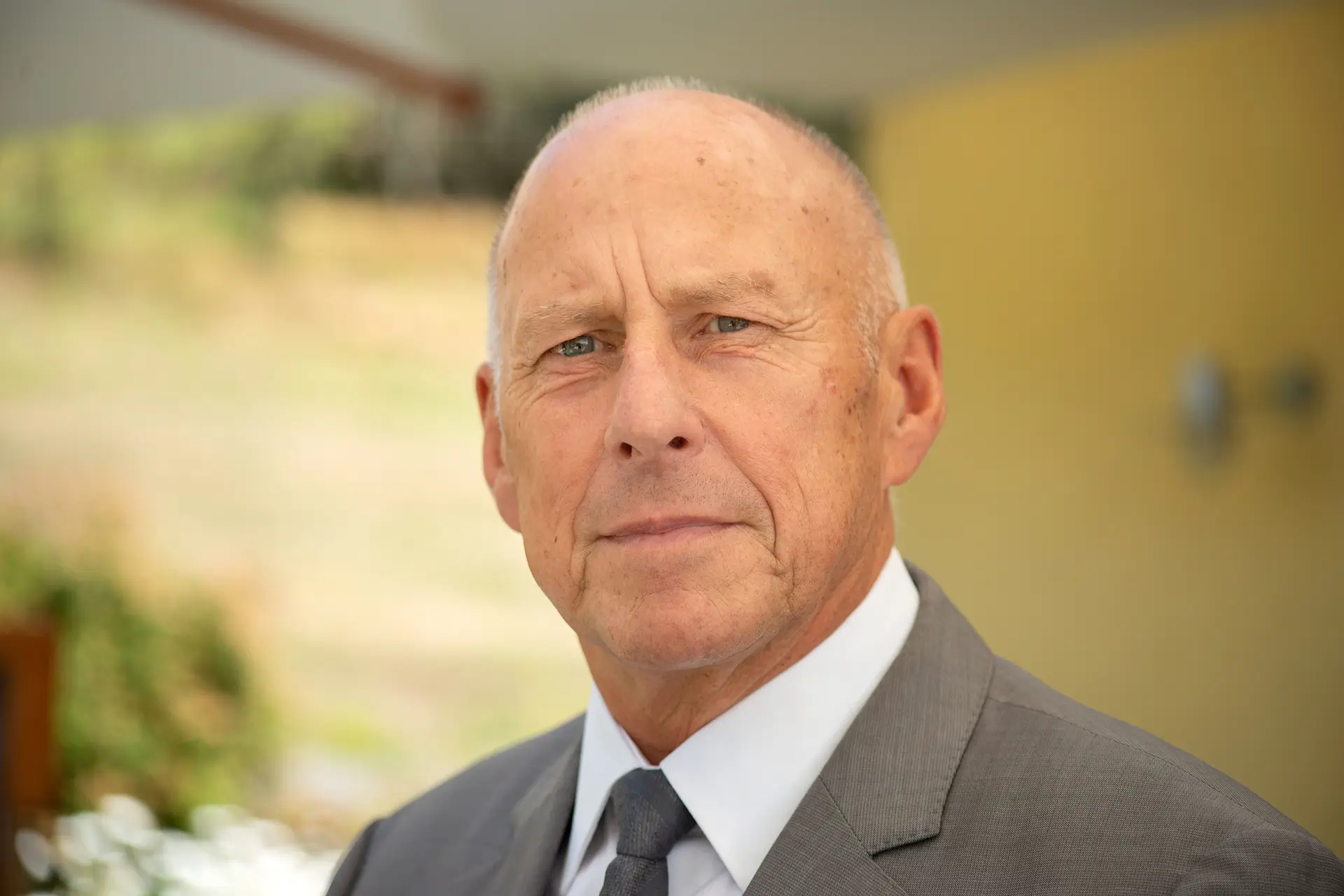 Ein Mann liegt auf einer Bank und drückt eine Langhantel, während zwei Personen daneben als Spotter stehen; im Hintergrund ist „Challenge 1“ zu sehen.