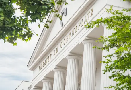 Nahaufnahme der Fassade des Theaters am Goetheplatz mit weißen Säulen und deutlich sichtbarer Beschriftung.